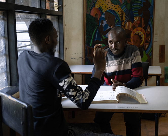 two men shown signing and gesturing to each other