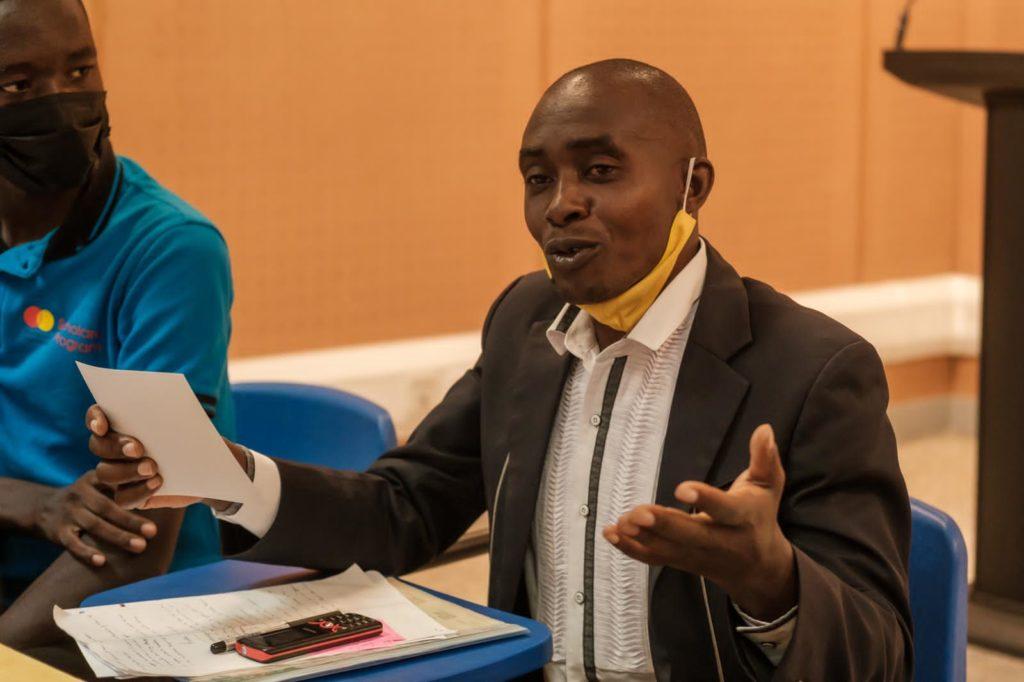 a man explains a point while others around him listen keenly